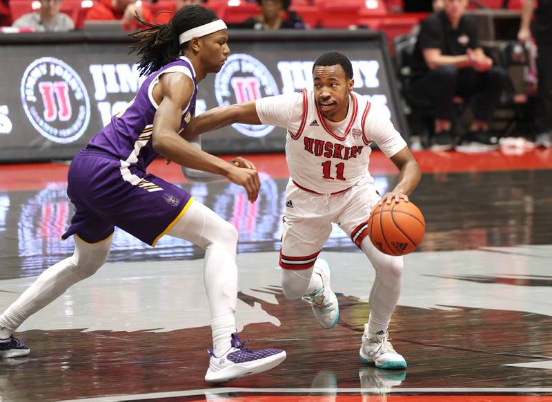 Northern Illinois Huskies guard David Coit drives by Albany Great Danes forward Aaron Reddish during their game Tuesday, Dec. 20, 2022, in the Convocation Center at NIU in DeKalb.