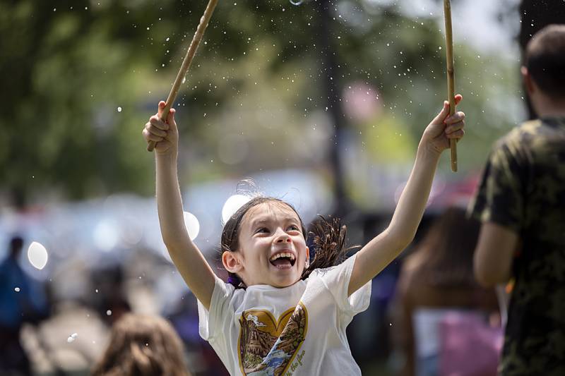 Skylar Book, 8, bursts her bubble Saturday, July 13, 2024 at Sterling’s Chalk the Walk.