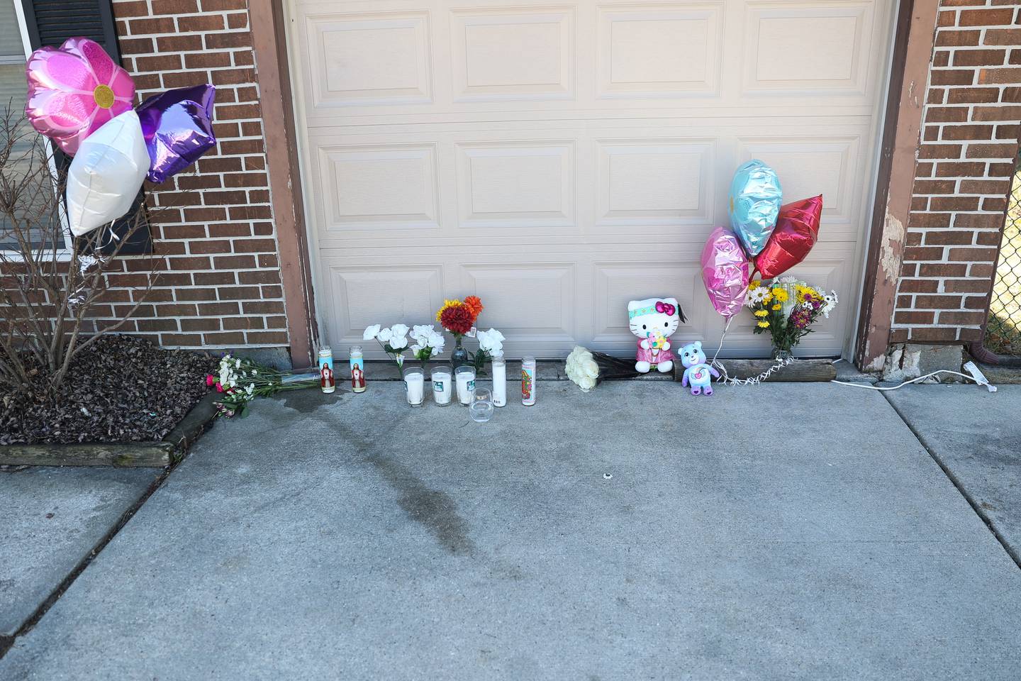 A memorial is set up outside the home along the 100 block of Lee Lane in Bolingbrook the day after a triple homicide.