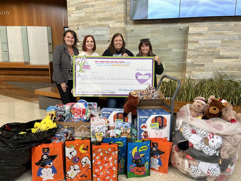 Silver Cross Hospital Corporate Giving and Events Coordinator Kelly Baltas, Silver Cross Director of Guest and Volunteer Services Laura Valencik, and Team Nicholas Founder Joanna Veghts, are presented with their big check by 100+ Women Who Care of Will County Founder Maribeth Carlson.  
Wednesday, Oct. 29, 2025.