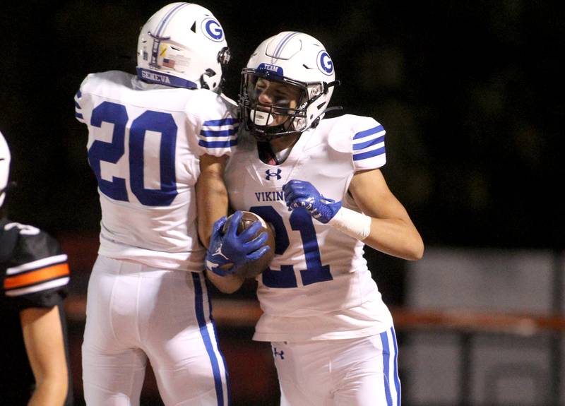 Geneva’s Anthony Pantano (20) and Michael Loberg (21) celebrate Loberg’s touchdown during a game at St. Charles East on Friday, Sept. 30, 2022.