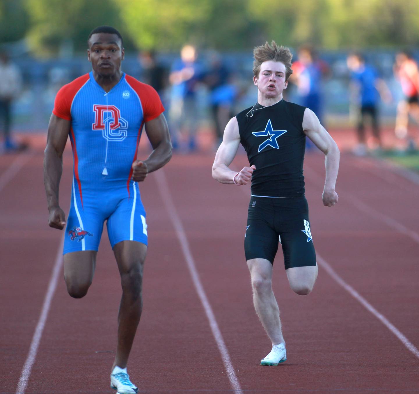 Dundee-Crown’s Oreoluwa Sobodu (left) and St. Charles North’s Wylder Smith (right) compete in the 100-meter dash during the Kane County boys track and field championships on Friday, May 9, 2025 at St. Charles North.