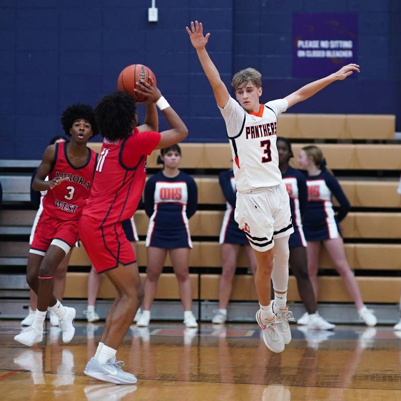 Oswego’s Nolan Petry (3) defends against a three point attempt by West Aurora's Jordan Brooks (11) during a basketball game at Oswego High School on Friday, Dec 1, 2023.