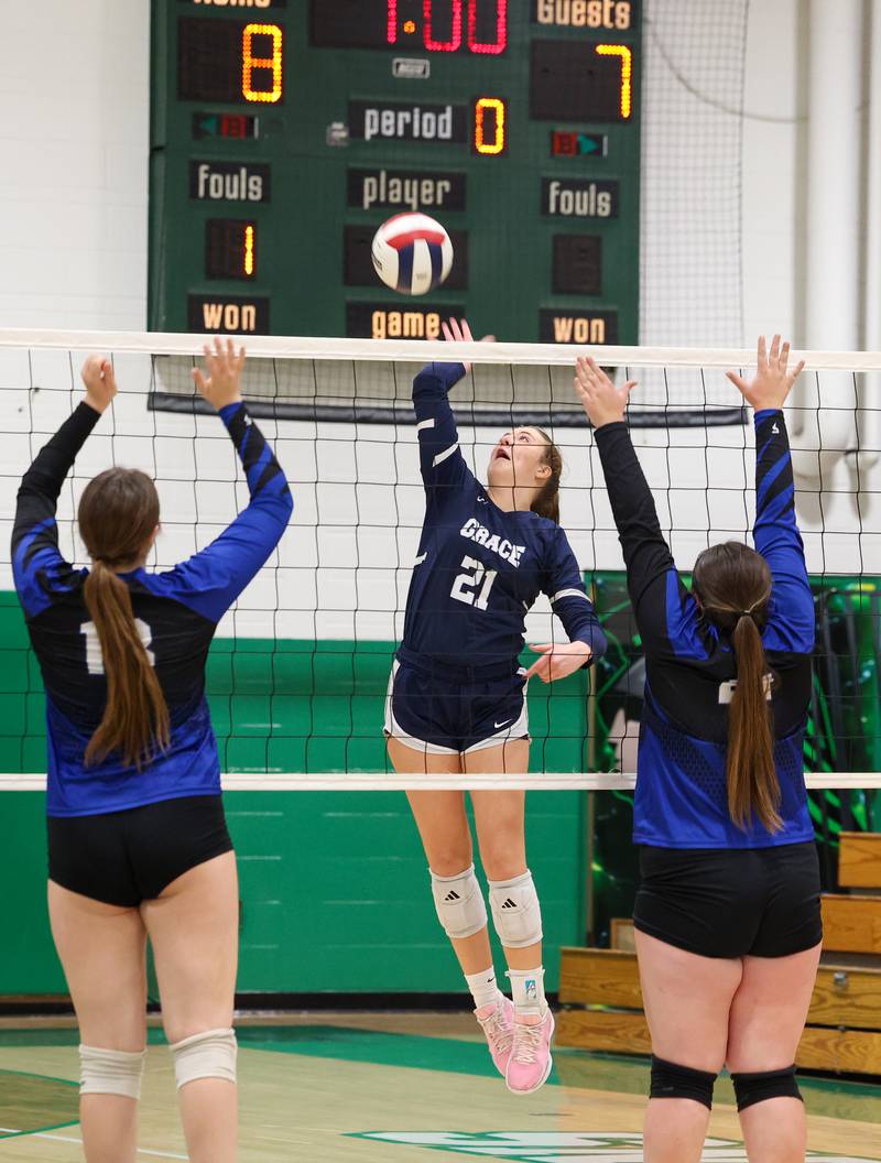 Grace Christian's Gracie Reynolds spikes the ball against Clifton Central's Gemma Sifrit, right, and Maddie Webb during the Crusaders' victory in two sets, 25-20, 25-16, over Clifton Central in the IHSA Class 1A Dwight Regional quarterfinals on Monday, Oct. 27, 2025.