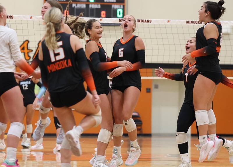 Minooka’s Kendall Kozak, center, celebrates a two set win over Joliet Catholic with her teammates on Wednesday, Sept. 4, 2024 in Minooka.
