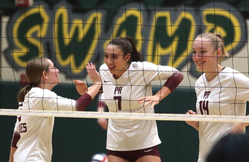 Prairie Ridge players, from left, Grace Jansen, Maizy Agnello and Jada Hoyt celebrate during a win over Woodstock North in IHSA Class 3A Sectional semifinal volleyball action on Tuesday, Nov. 5, 2024, at  Crystal Lake South High School  in Crystal Lake.
