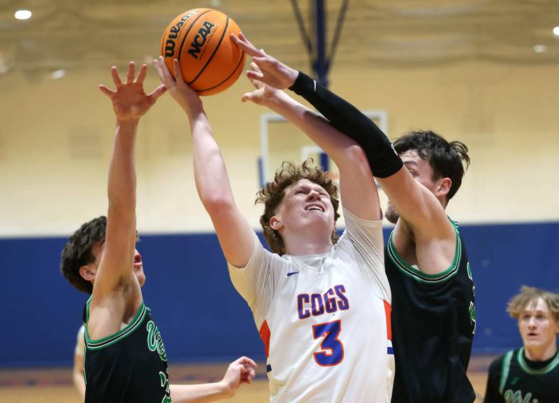 Genoa-Kingston's Jack Peterson goes to the basket between two North Boone defenders during their Class 2A regional game Monday, Feb. 24, 2025, at Genoa-Kingston High School.