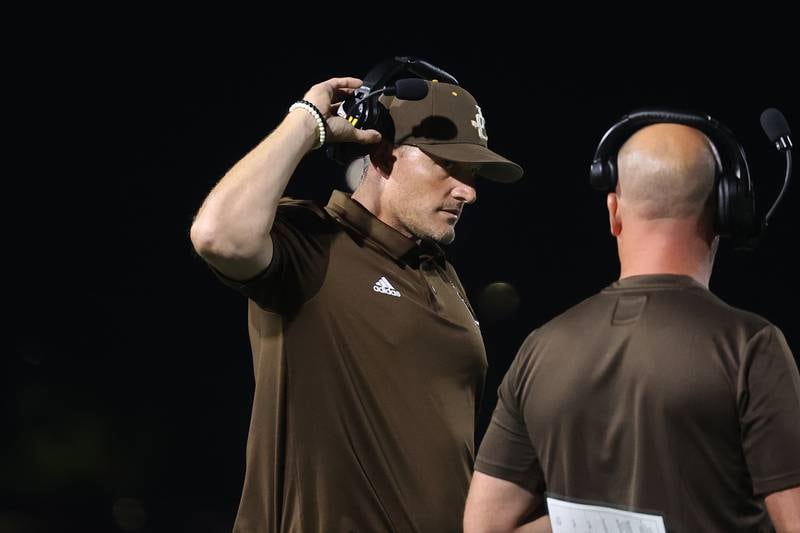 Joliet Catholic assistant coach Brett Boyter talks with Jake Jaworski during a timeout against Providence on Friday, Sept. 1, 2023 Joliet Memorial Stadium.