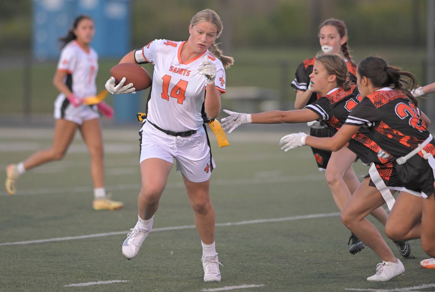 St. Charles East’s Brynn Maple avoids the reach of Wheaton Warrenville South’s Gracyn Mangelsen in a flag football game in Wheaton on Monday, Sept. 8, 2025.