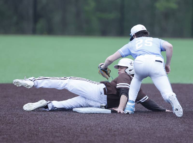 Nazareth's Landon Thome (25) tags out Joliet Catholic's Vincent Bremner II (32) during the varsity baseball game on Wednesday, April 20, 2025 between Nazareth and Joliet Catholic academies in La Grange Park.