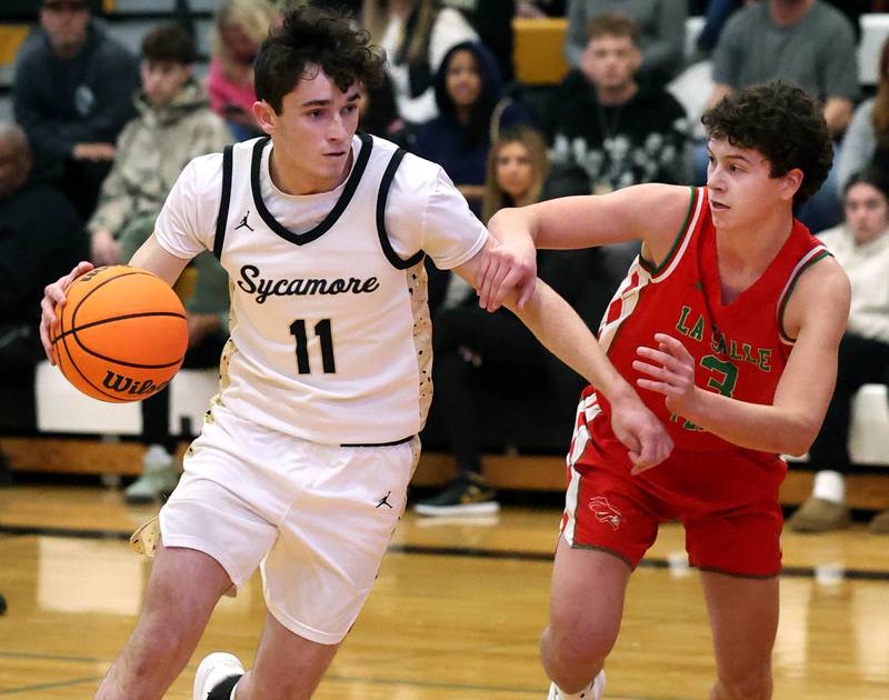 Sycamore's Jake Shipley drives the lane against La Salle-Peru's Mikey Hartman during their game Tuesday, Feb. 4, 2025, at Sycamore High School.