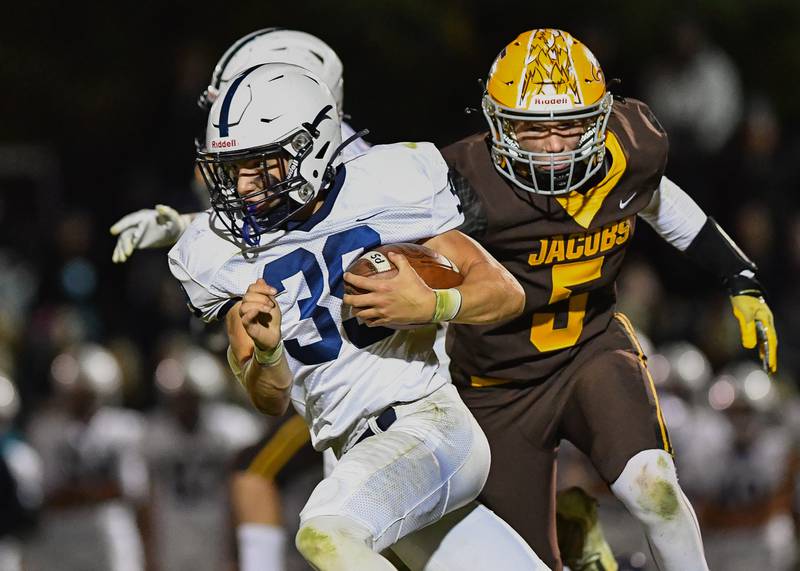 Cary Grove's Holden Boone looks for yardage against Jacob's Nicholas Gallo during their Fox Valley Conference game on Friday, Oct. 6, 2022 in Algonquin.