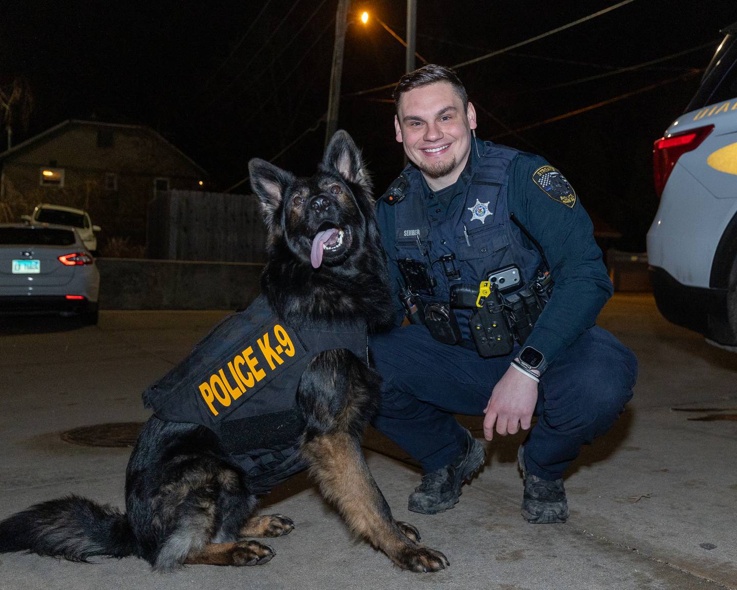 K9 Patrolman Trevor Sember poses with K9 'Bo' in front of patrol car on Friday, January 9, 2026, at the Streator Police Department in Streator. 'Bo' and the Streator Police Department were gifted a protection vest by 'Vested Interest in K9s, Inc.'