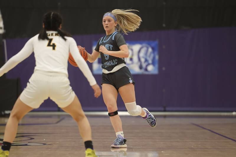 Joliet Catholic’s Indrid Troha works the ball up the court against Joliet West in the WJOL Basketball Tournament at Joliet Junior College Event Center on Monday