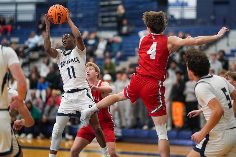 Oswego East's Reginald McWaine (11) rebounds the ball against Hinsdale Central during a hoops for healing tournament basketball game at Oswego East High School on Tuesday, Nov. 26, 2024.