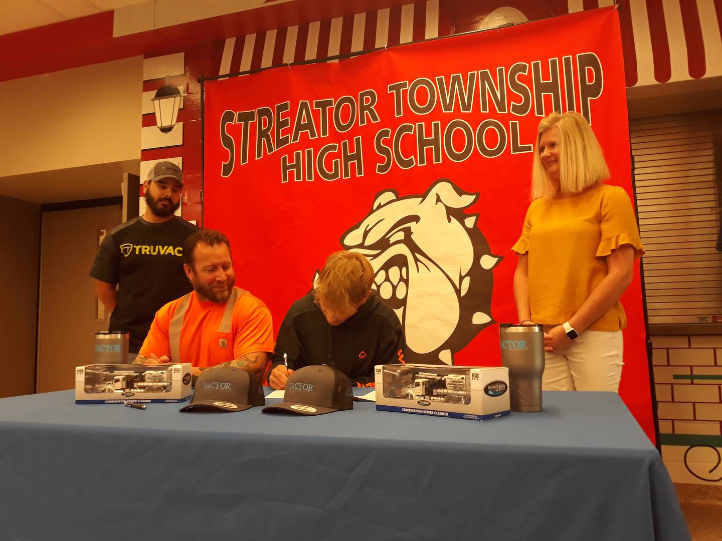 Streator High School senior Keegan Emm signs a letter to intent Tuesday, May 17, 2022, to work at Vactor Manufacturing, while (left to right) Shayne Schuler, welding supervisor at Vactor; Mark Emm, his father; and Katie Muntz, human resources manager, look on.
