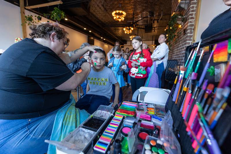 Martin Gutierrez gets face painted by 'Crazy Cat Lady Face Painting' at the annual Christmas in the Valley on Saturday, November 15, 2025 at Core Cafe in Spring Valley.