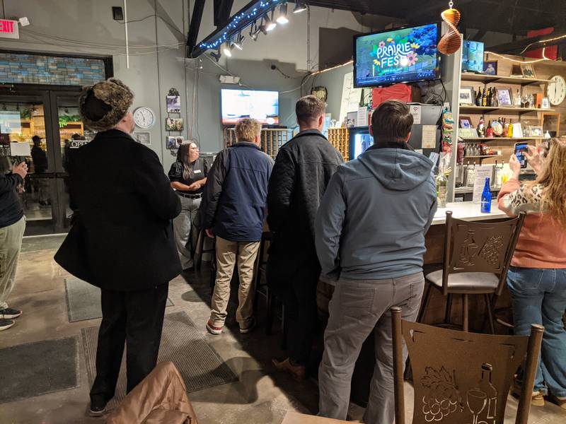 People watch a screen as this year's band lineup is announced Jan. 21 at the PrairieFest Partner Preview Night at the Fox Valley Winery in downtown Oswego.