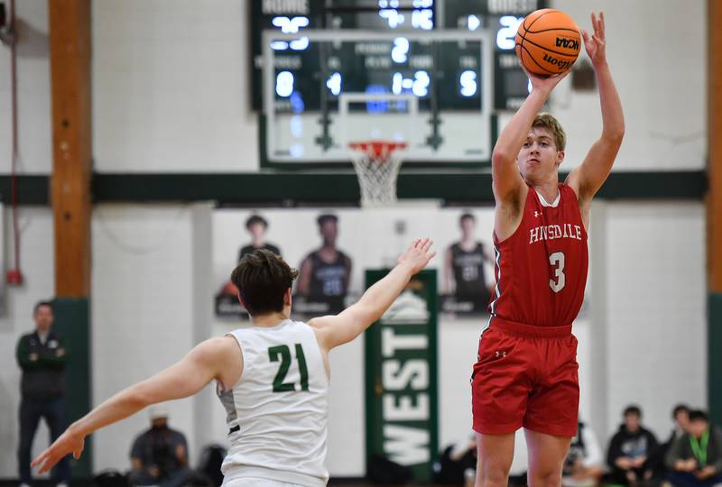 Hinsdale Central’s Dillon Dell (3) shoots from three point range as Glenbard West’s Bryce Huff (21) defends during a game on January 31, 2025 at Glenbard West High School in Glen Ellyn.