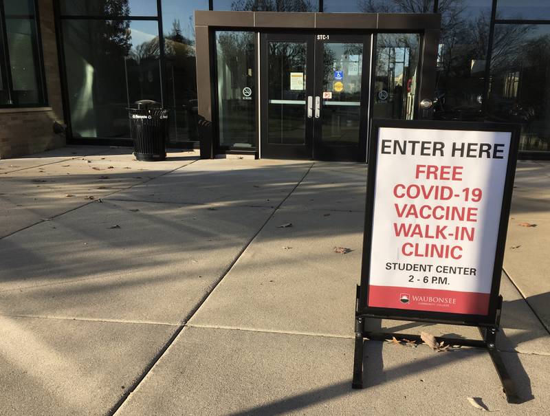 FILE PHOTO: A sign outside Waubonsee Community College's student center building in Sugar Grove directs people to a walk-in COVID-19 vaccine clinic Dec. 8, 2021.