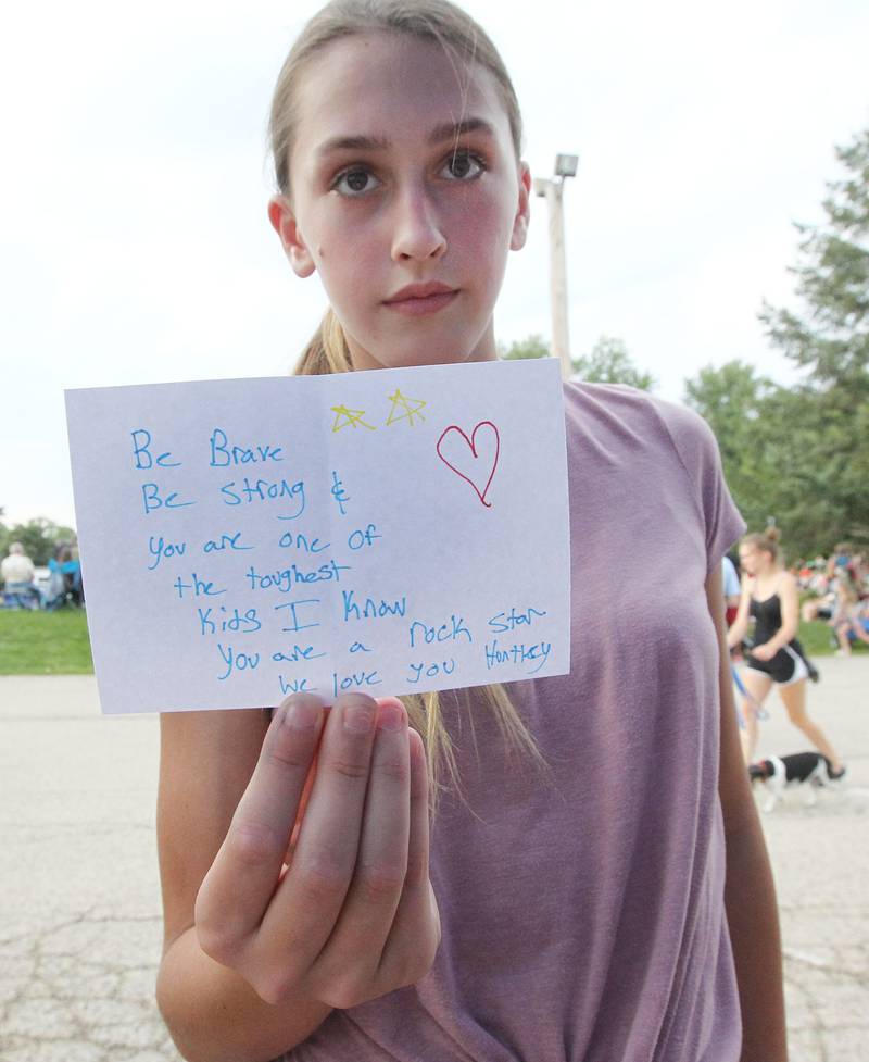 Kaile Maloney, 12, of Antioch shows the note she wrote for Huntley during the final concert of the "It’s Thursday” summer concert series on August 10th in Antioch. The event and its proceeds were dedicated to Huntley, a child who was injured during the Taste of Summer in July. 
Photo by Candace H. Johnson for Shaw Local News Network