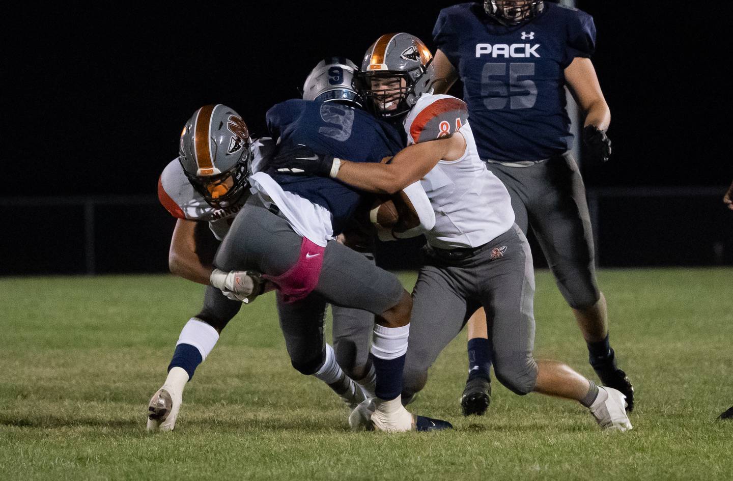 Minooka's Isaiah Dupree (left) and Will DeBold (84) hit Oswego East's Tre Jones (9) in the backfield for a loss during a varsity football game at Oswego East High School in Oswego on Friday, Oct 1, 2021.
