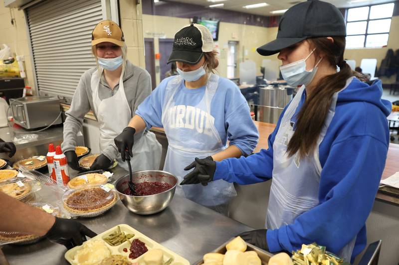 Olivia Cosgrove, left, her sister Nora and Annie Simon serve the desserts for members of the community at the Daybreak Center on Thanksgiving Day in Joliet.