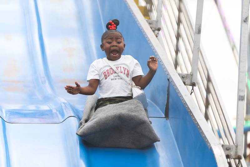 Elanah Dorsey, 7-years old, screams while going down the carnival slide on day 2 of the Taste of Joliet. Saturday, June 25, 2022 in Joliet.