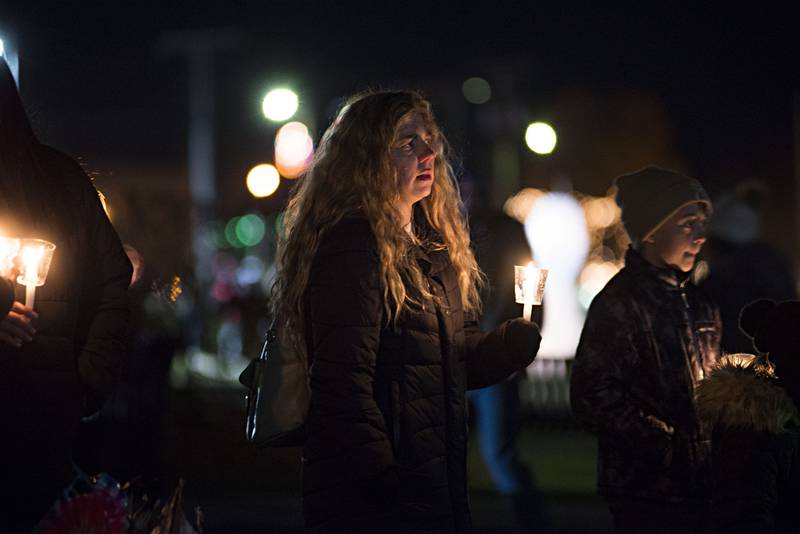 Family and friends honor their loved ones with lit candles during the reading of the names at the Lovelight Tree during Rock Falls’ Hometown Holiday’s celebration on Friday, Nov. 19, 2021. 642 names of lost loved ones were read during the ceremony.