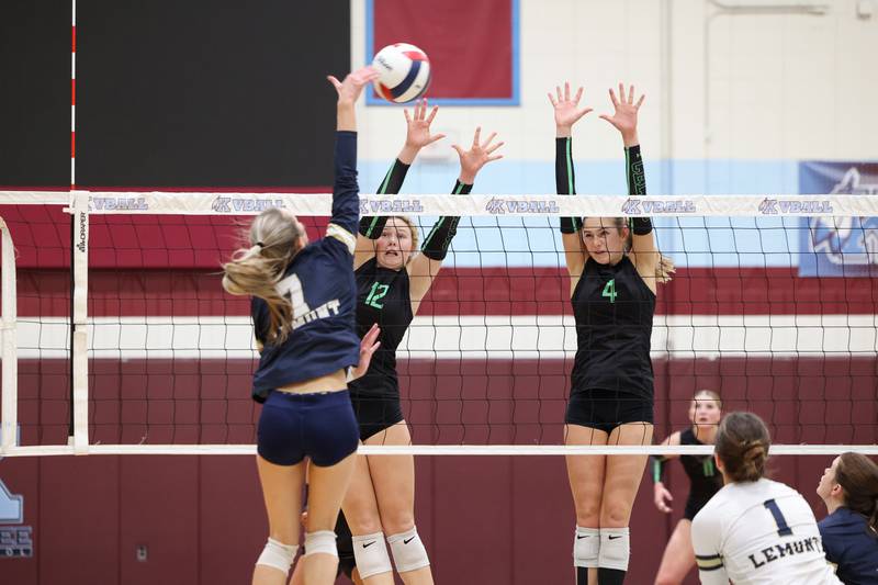 Providence's Kennady Kotowski (12) and Lilly Lipke jump to block a hit by Lemont's Fiona Tkach during Providence's victory in two sets, 25-25, 25-18, over Lemont in the IHSA Class 3A Kankakee Sectional championship on Thursday, Nov. 6, 2025.