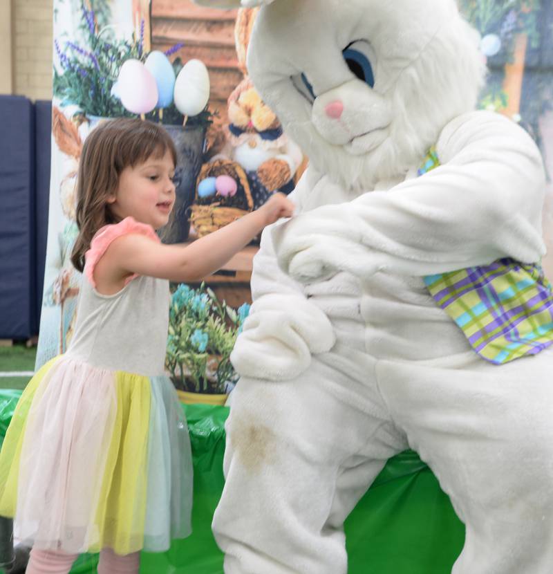 Eleanor  DeLeo of Glen Ellyn gives the Easter Bunny a fist bump during the Glen Ellyn Park District's Hoppy party Saturday, March 30, 2024.