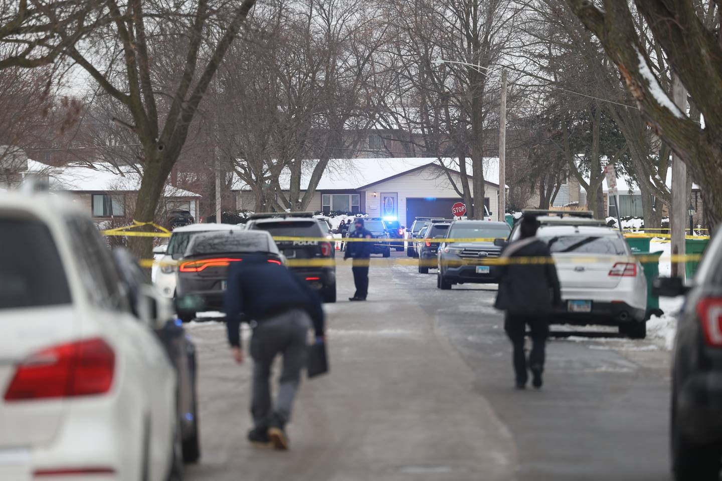 Police walk along West Acres Road at the scene were multiple people were found dead in two homes on Monday, Jan. 22nd in Joliet.