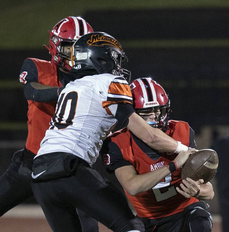 Milledgeville’s Evan Schenck smacks a potential interception away from Amboy’s Eddie Jones Friday, Nov. 22, 2024, during the 8-man football championship in Monmouth.