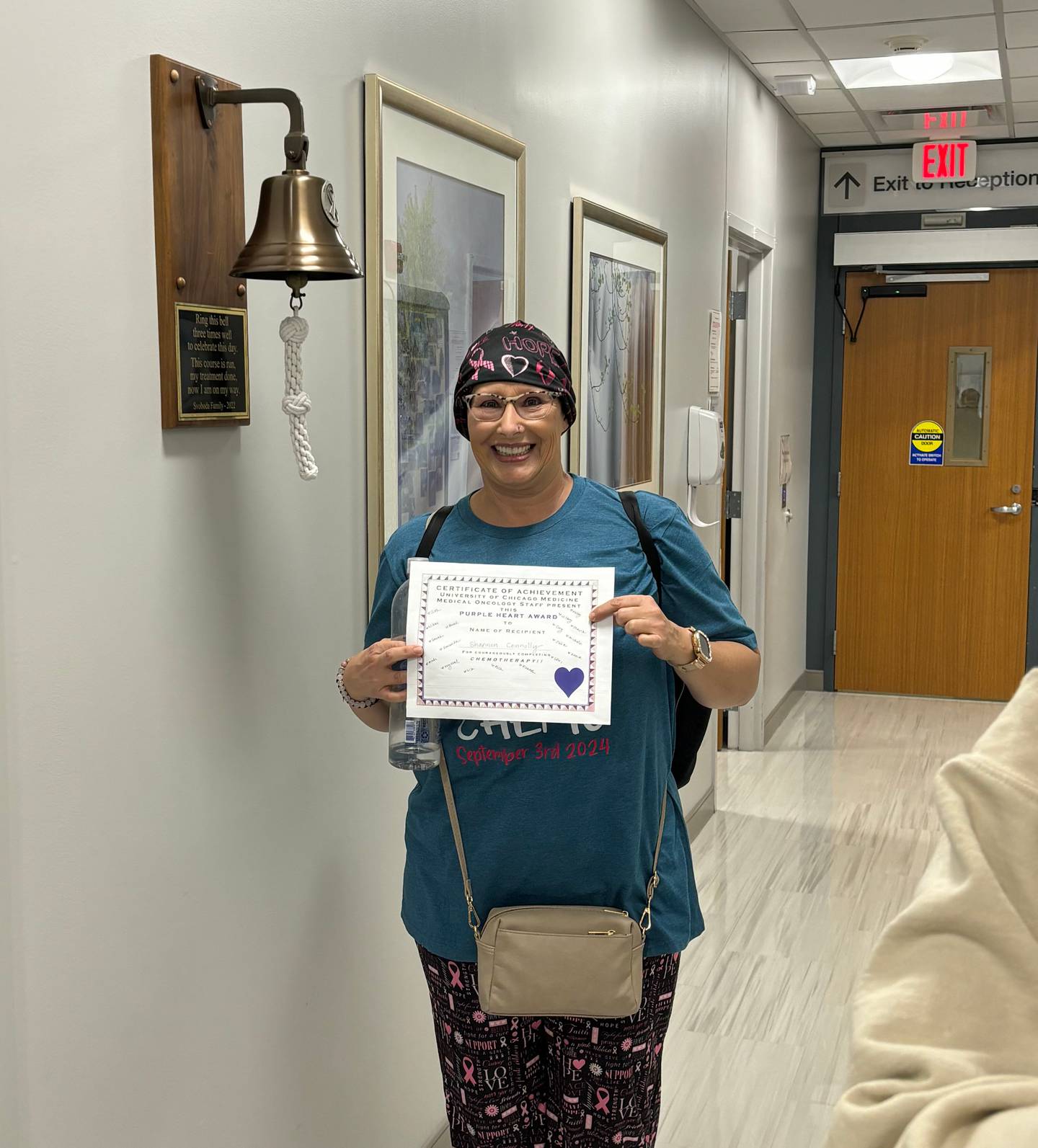 Shannon Connolly holds the Purple Heart Award on her last day of chemo therapy at Silver Cross Hospital in New Lenox.