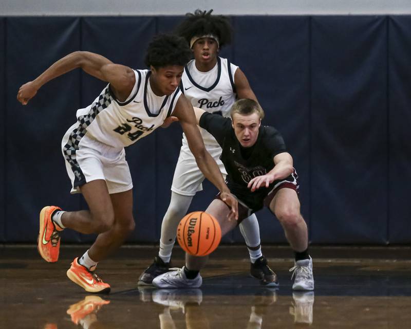 Oswego East's Dshaun Bolden (24) pokes the ball away from Plainfield North's Carson Miller (30) during their basketball game between Plainfield North at Oswego East Friday, Dec 5, 2025 in Oswego.