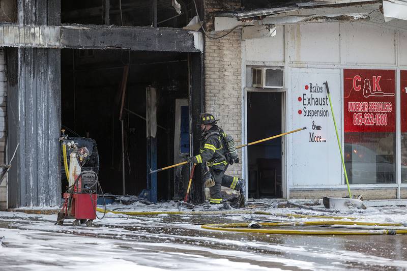 After dousing the fire with foam, firefighters look to check the ceiling for hot spots Friday, Nov. 7, 2025, in Sterling.