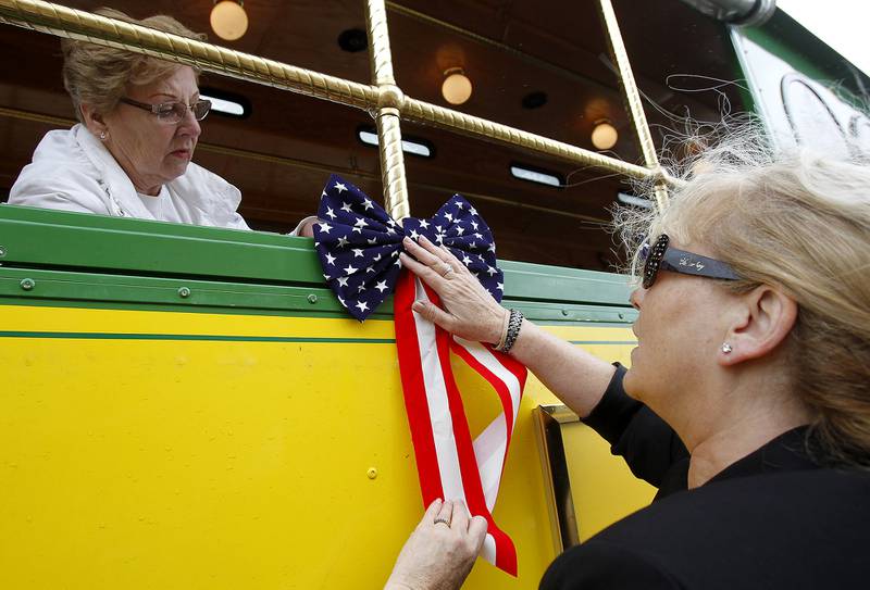 Priscilla Dvoracek of Lakewood, left, helps Stacey Collins of Crystal Lake decorate a trolley with red, white, and blue ribbons before the annual Memorial Day parade on Monday, May 25, 2015 in Crystal Lake. Matthew Apgar - mapgar@shawmedia.com