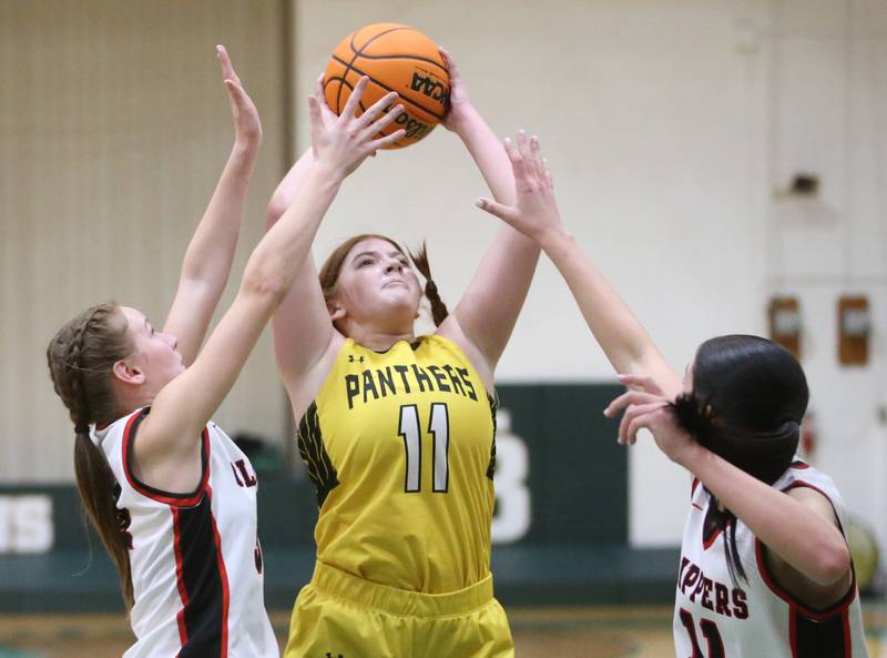 Putnam County's Maggie Spratt eyes the hoop as Amboy/Ohio's Belle McLaughlin and Tyrah Vaessen defend during the Class 1A Regional semifinal game on Tuesday, Feb. 18, 2025 at St. Bede Academy.