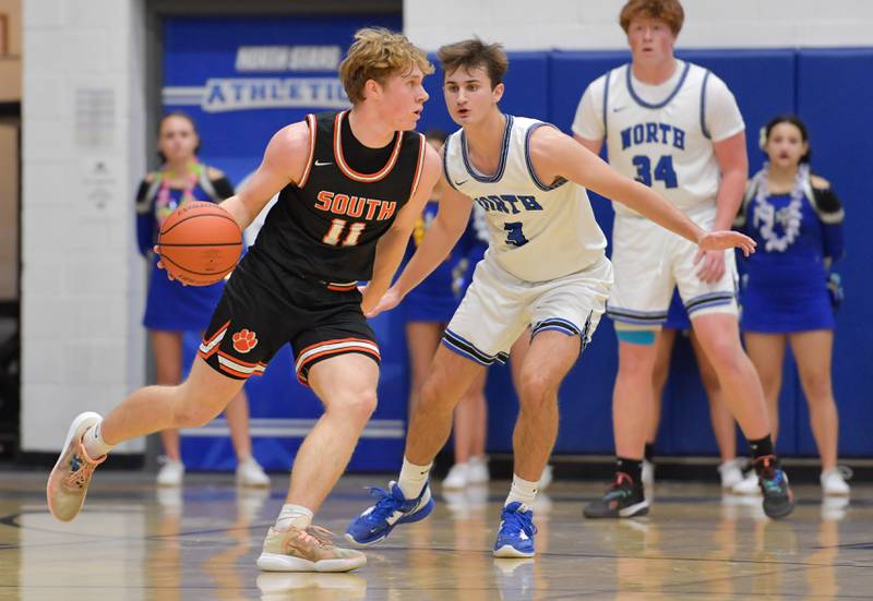 Wheaton Warrenville South Colin Moore (11) drives around St. Charles North's Cameron Ring (3) during a game on Friday, December 2, 2022.
