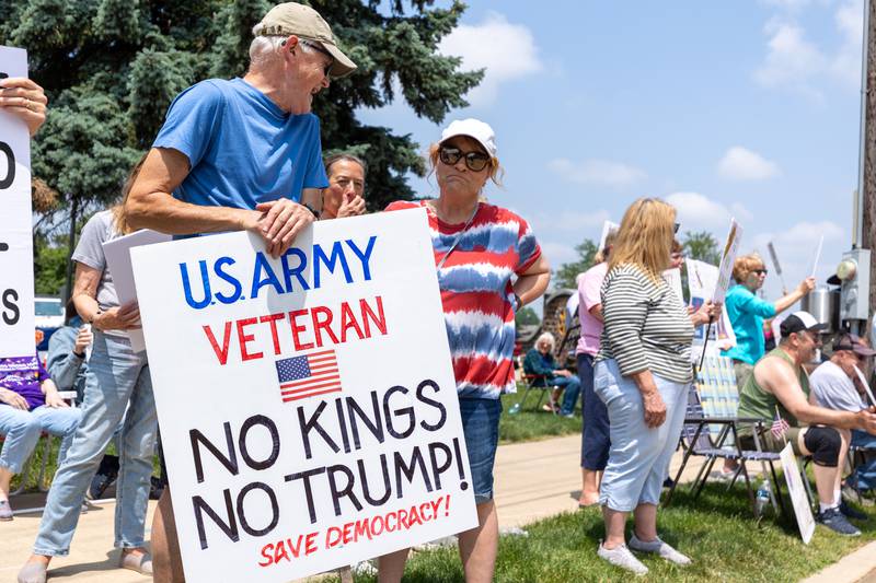Protesters hold signs at the “No Kings“ protest on Saturday, June 14, 2025 at Rotary Park in Princeton.