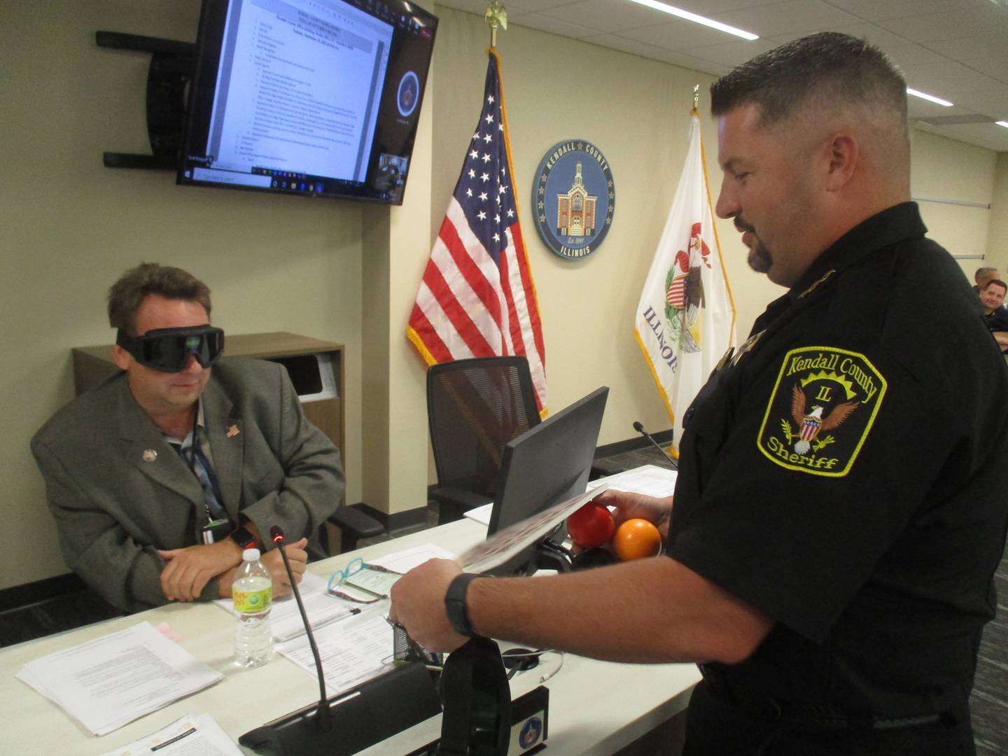 Kendall County Board member Dan Koukol prepares to take a maze test offered by Kendall County Undersheriff Bobby Richardson while wearing goggles simulating the effects of marijuana.