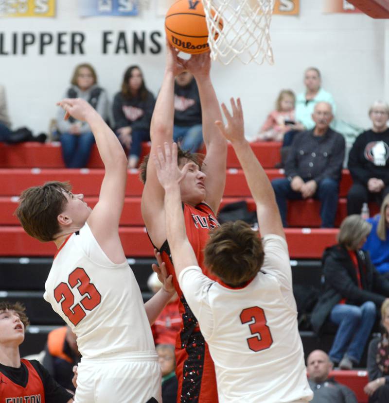 Fulton's Landen Leu (10) rebounds against Amboy's Bryson Deery (23) and Brody Christofferson (3) on Friday, Jan. 17, 2025 at Amboy High School.