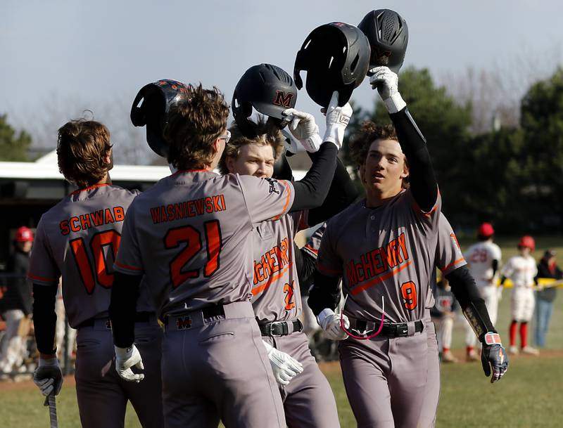 McHenry’s Carver Cohn (right) celebrates his grand slam home run with his teammates during a Fox Valley Conference baseball game against Huntley on Friday, April 11, 2025, at Huntley High School.