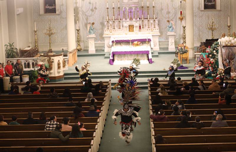 Dancers perform down the main isle at St. Patrick's Catholic Church during the Lady of Guadalupe vigil Chichimeca dance on Thursday, Dec. 12, 2025 in La Salle. The Chichimeca dance is a vibrant, Indigenous-rooted devotional tradition where dancers (Danzantes) perform to honor the Virgin Mary's appearance to Juan Diego in 1531, symbolizing faith, hope, and cultural fusion, often involving elaborate costumes, feathers, and drumming, leading up to the main Feast Day on December 12th, with celebrations happening globally in parishes.