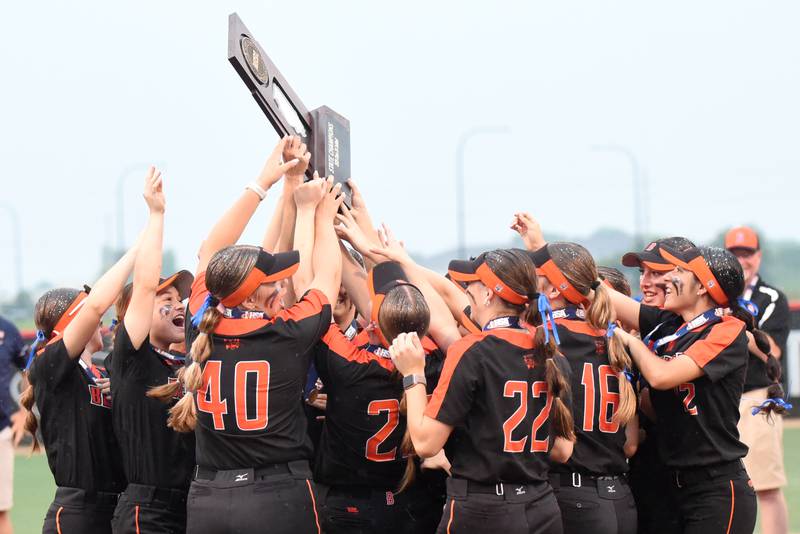 The Beecher softball team celebrates with the Class 2A State championship trophy after defeating Carterville 5-2 in 10 innings in the championship game at the Louisville Slugger Complex in Peoria Saturday, June 7, 2025.