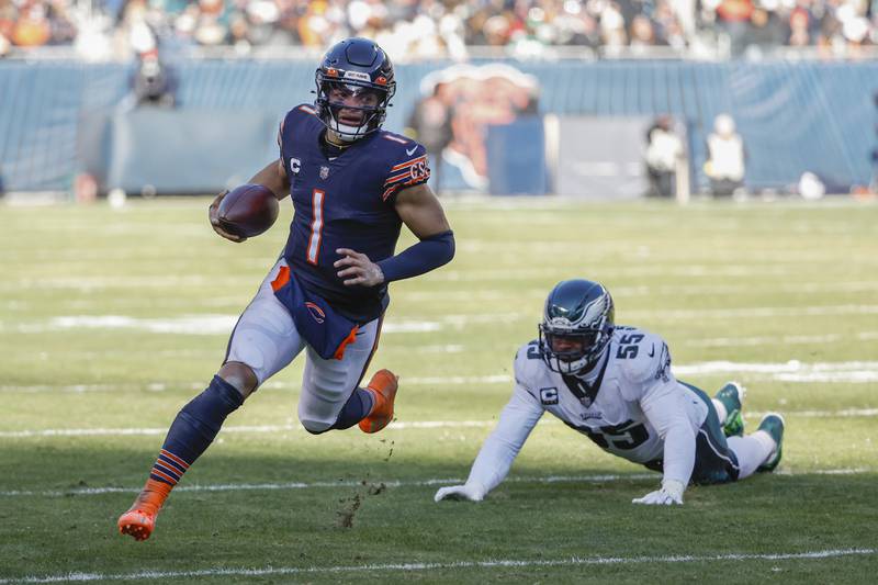 Chicago Bears quarterback Justin Fields rushes past Philadelphia Eagles defensive end Brandon Graham during the first half, Sunday, Dec. 18, 2022, in Chicago.
