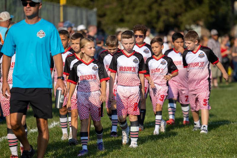 Team Ruiz Construction walks during the parade at the opening day ceremony of youth soccer on Saturday, Aug 16, 2025, at Peck Park in Ottawa.