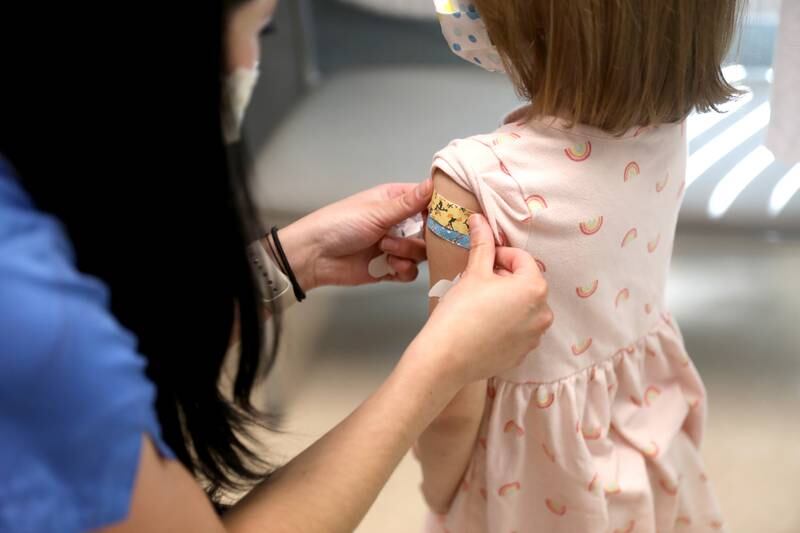 Registered Nurse Samantha Bartulis puts a Band-Aid on Sofie Reschak, 4, of Crystal Lake at a Northwestern Medicine medical office on Friday, July 22, 2022. Sofie was there for her back-to-school booster shots.