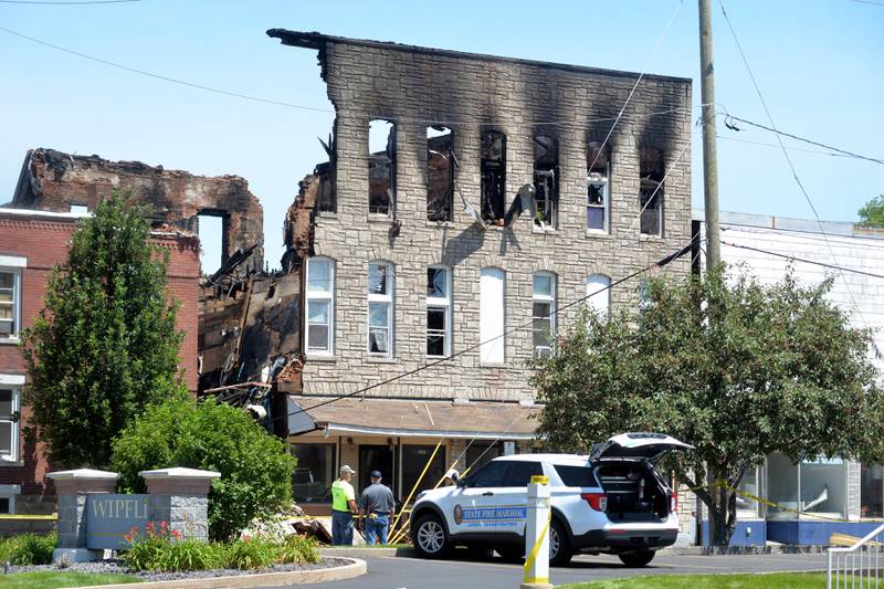 Two people examine the remains of  an early morning fire at 406 East Third Street in Sterling destroyed a 3-story building.