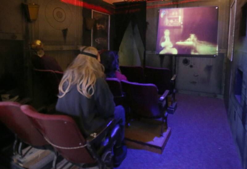 An erie vintage movie plays on a screen inside of a fake theater of the Insanity Haunted House on Thusday, Oct. 3, 2024 at the Peru Mall. There is so much detail inside the haunted house and that's what sets it apart from other haunted houses throughout the State of Illinois.